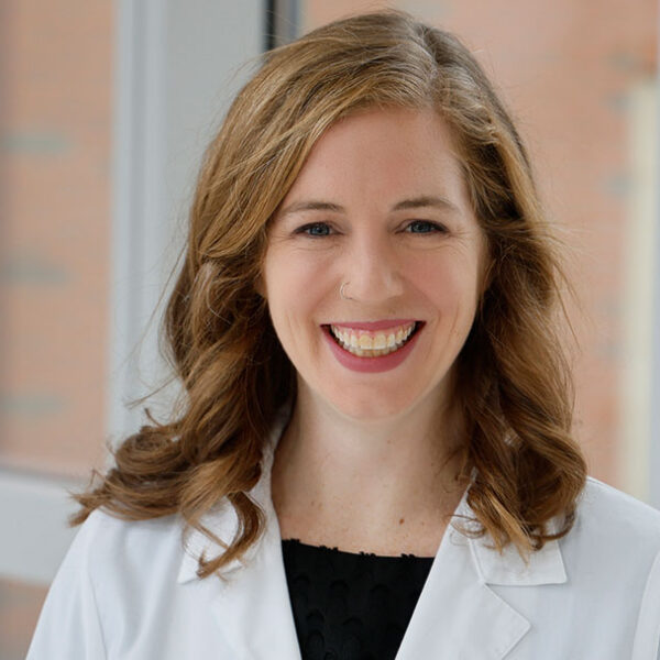 A photograph of Dr. Meaghan Costello smiling and wearing a doctor's exam jacket.